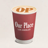 Red coffee cup with 'Our Place Los Angeles' text on a beige background