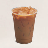 Plastic cup of iced coffee with ice cubes on a beige background
