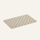 Checkered bath mat with beige and white squares on a light gray background
