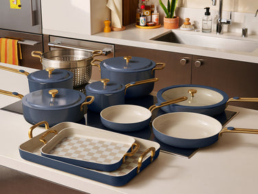 Set of blue cookware with gold handles on a kitchen counter