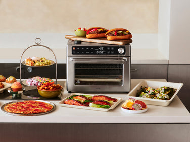 Multifunctional kitchen appliance with various food items on a countertop