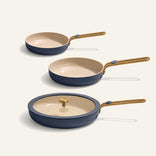 Set of three frying pans with beige interiors and blue exteriors on a white background