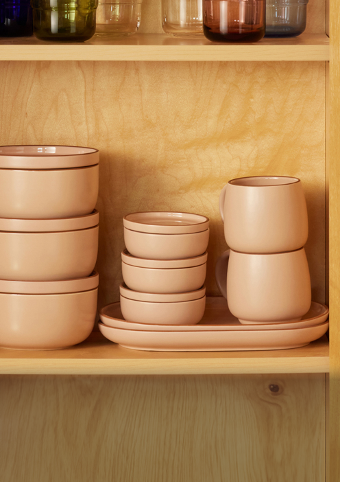 Pink Night + Day Mugs with matching dinnerware on a shelf