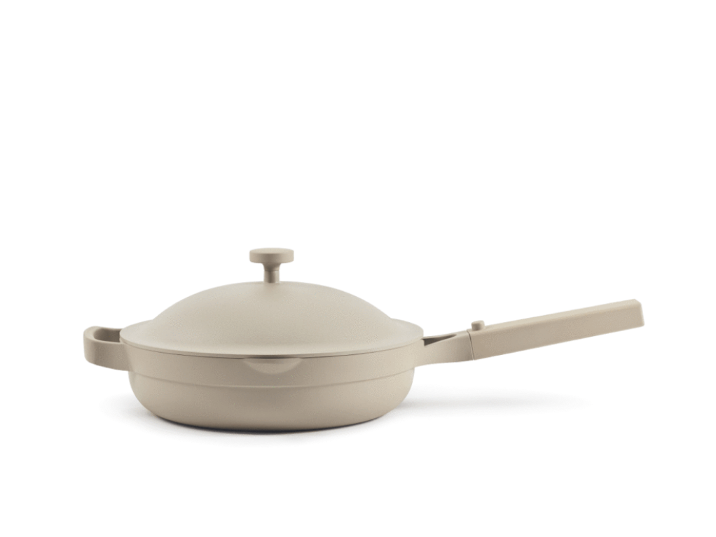 A beige, nonstick frying pan with a matching lid, long handle, and helper handle, placed on a plain white background.