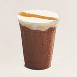 Chocolate drink with whipped cream and a dusting of cinnamon on a light beige background
