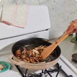 beige cast iron always pan sautéing mushrooms