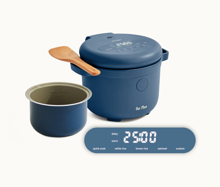 A blue electric rice cooker with a wooden spatula, removable inner pot, and digital display showing timer and cooking options including quick cook, white rice, brown rice, oatmeal, and custom.