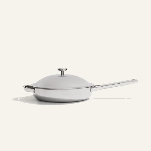 A stainless steel Titanium Always Pan Pro 10.5″ 2.0 skillet with a matching lid and a long handle.