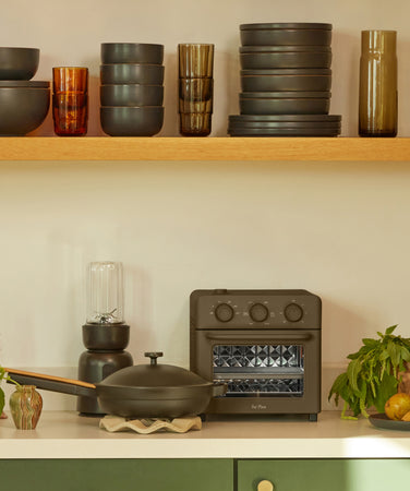 black perfect pot, mini always pan, mini perfect pot on stove, black splendor blender, always pan and wonder oven on counter