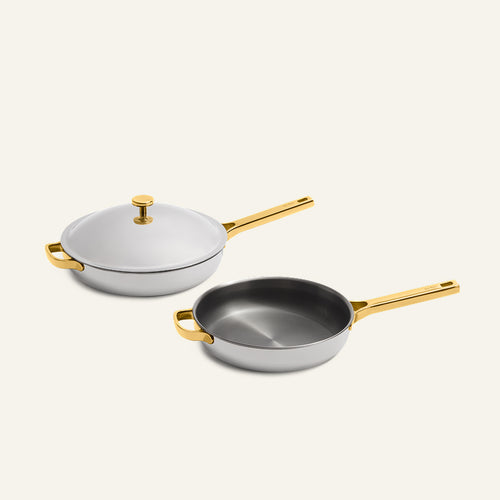 Titanium Pro Always Pan Duo 2.0 set including two light gray non-toxic frying pans with gold-colored handles and one matching lid.