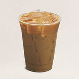 Plastic cup of iced coffee with ice cubes on a light beige background