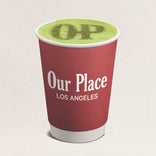 Red cup with green beverage and 'Our Place Los Angeles' text on a beige background