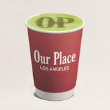 Red cup with green beverage and 'Our Place Los Angeles' text on a beige background