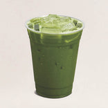 Green iced drink in a clear plastic cup on a light beige background