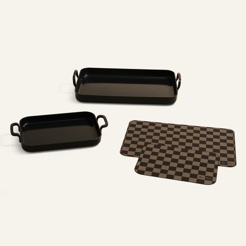 Two black rectangular trays and two checkered mats on a light gray background