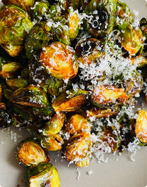 Roasted Brussels sprouts with Parmesan cheese on a white plate