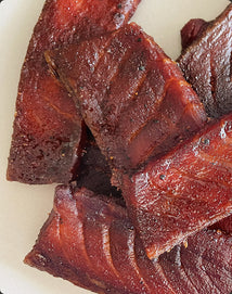Dried beef jerky pieces on a white plate