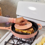 pink cast iron always pan with hot grill on stovetop