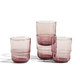 A set of five translucent pink glass tumblers of varying heights, arranged on a clean white background.