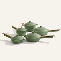 Set of green cookware with wooden handles on a white background