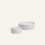 Small Plates Set featuring stacked white ceramic plates with gold rims, arranged in two groups on a plain light background.