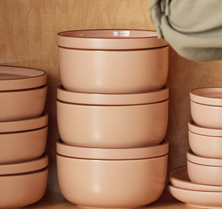 Pink Our Place bowls and plates arranged as a tableware set