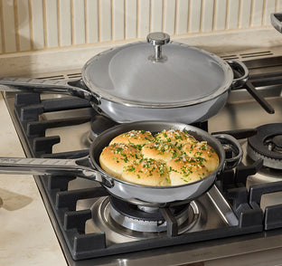 Pancakes with green herbs in a pan on a gas stove